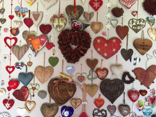 a bunch of hearts hanging on a wall at Nido d’amore nei colori in Dernice