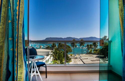 a balcony with a view of the pool and palm trees at Hotel Ilhabela in Ilhabela