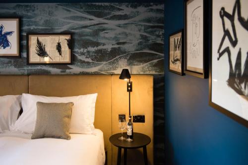 a bedroom with a bed and a table with a lamp at Hotel Du Vin Stratford in Stratford-upon-Avon