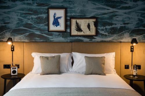 a bedroom with a bed with two lamps and a painting on the wall at Hotel Du Vin Stratford in Stratford-upon-Avon