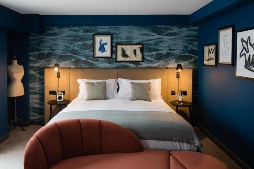a bedroom with a large bed and a chair at Hotel Du Vin Stratford in Stratford-upon-Avon
