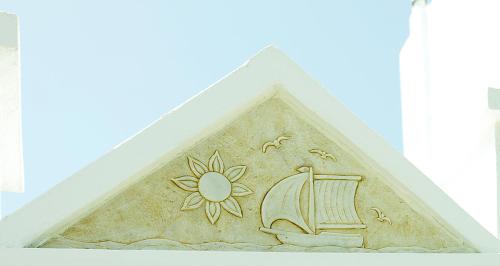 a building with a relief of a ship and a sun at Mata's Apartments in Tinos Town