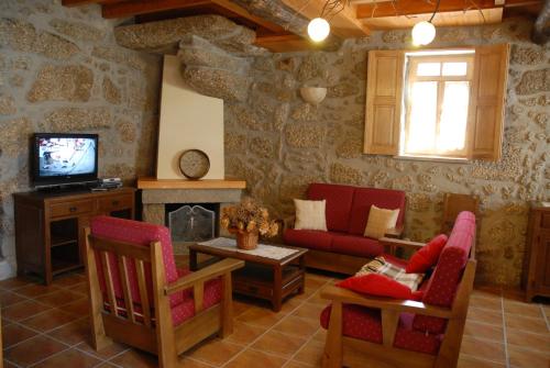 a living room with a couch and a tv at Casa da Moreia in Sabugueiro