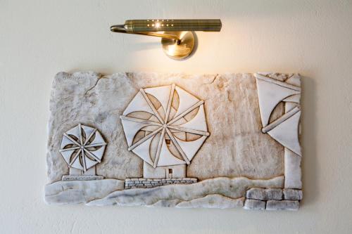 a towel hanging on a wall with a light on it at Mata's Apartments in Tinos Town