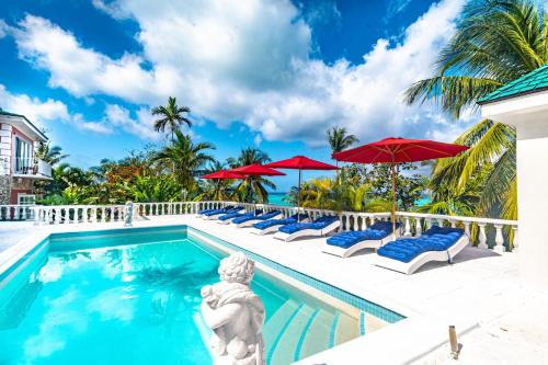 a pool at the resort with chairs and umbrellas at Panoramic Cottage at Viking Hill - Love Beach in Nassau
