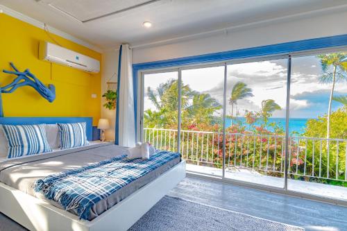a bedroom with a bed and a view of the ocean at Panoramic Cottage at Viking Hill - Love Beach in Nassau