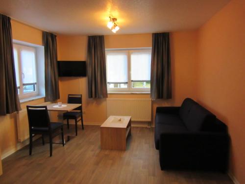 a living room with a couch and a table at Hotel-Gasthaus Steiger in Gräfenthal