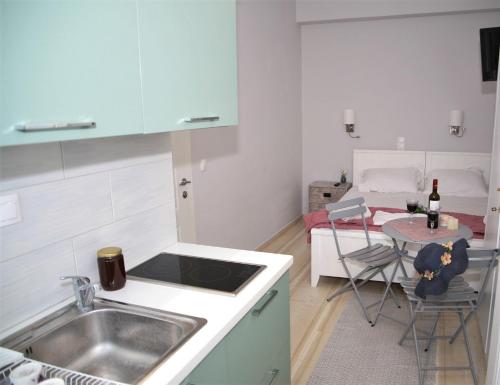 a kitchen with a sink and a table with a bed at Terpsichore Boutique Appartments in Dassia
