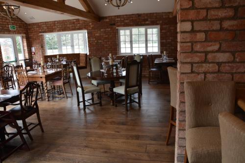 a dining room with tables and chairs and a brick wall at The Parsonage Hotel & Spa in York