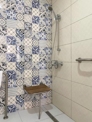 a bathroom with a shower with a bench in it at Fortunella Suites in Finike