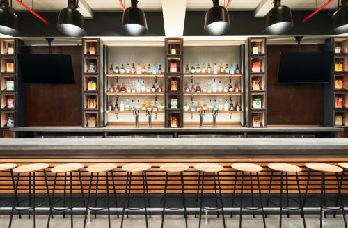 a bar with a row of stools at Hotel Indigo Tallahassee - Collegetown by IHG in Tallahassee