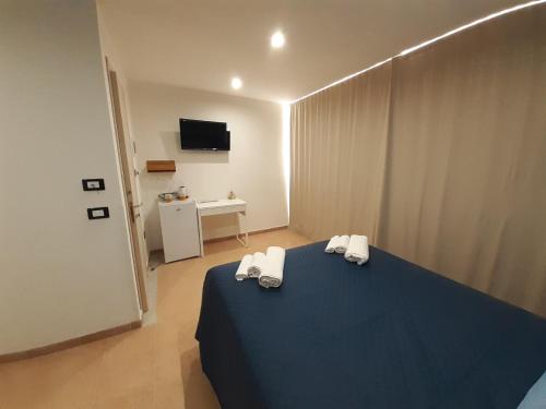 um quarto com uma cama azul com toalhas em La Casetta sul Mare em Isola delle Femmine
