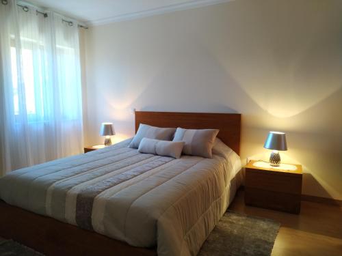 a bedroom with a large bed with two lamps at Casa da quintinha - Turismo rural in Arcos de Valdevez