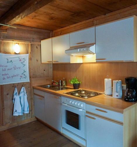 a kitchen with a white stove and a sink at Angererhof in Jochberg