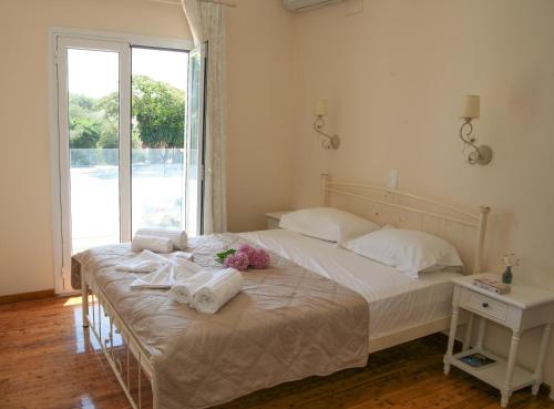 a bedroom with a bed with towels and a window at Terpsichore Boutique Appartments in Dassia