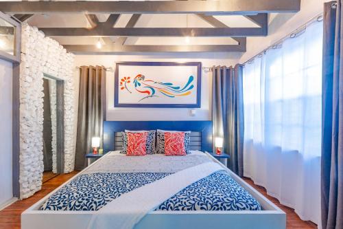 1 dormitorio con 1 cama azul y blanca y 2 lámparas en Parrot Cottage at Viking Hill - Love Beach, en Nassau