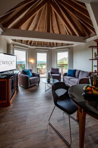 a living room with a couch and a tv at Sporthotel Leweck in Lipperscheid
