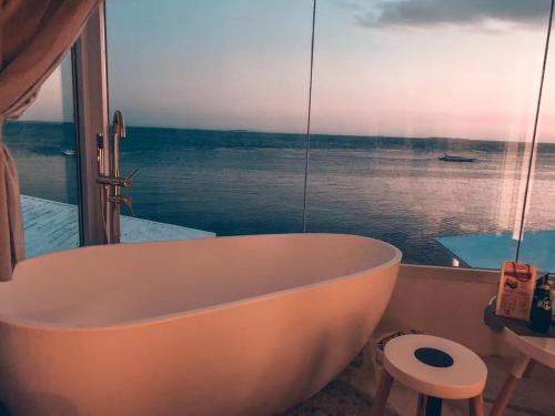 a bath tub in a bathroom with a view of the ocean at Sugarsea Inn & Dive shop in Mactan