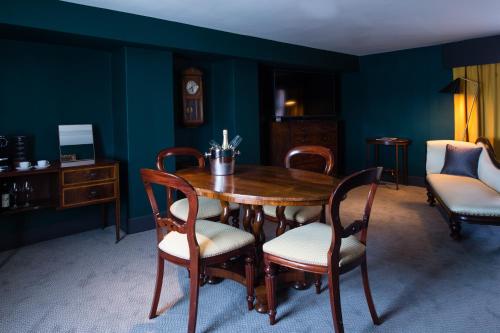 a dining room with a wooden table and chairs at Hotel Du Vin Stratford in Stratford-upon-Avon