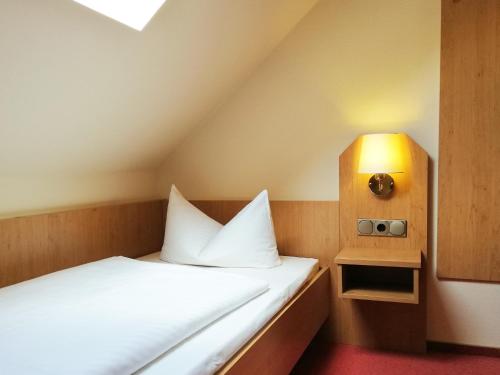 um quarto com uma cama com uma luz sobre ela em Hotel Burgas em Stassfurt