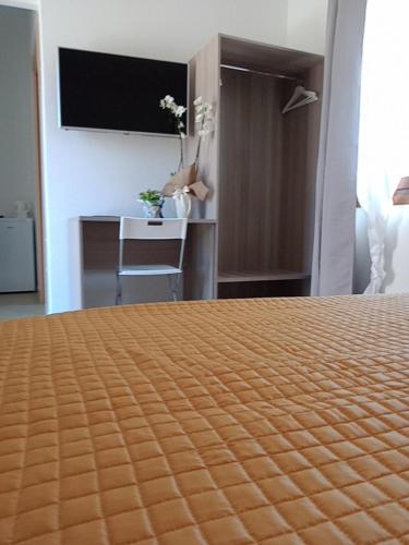 a hotel room with a bed and a television at Villa Orsola in Villaputzu