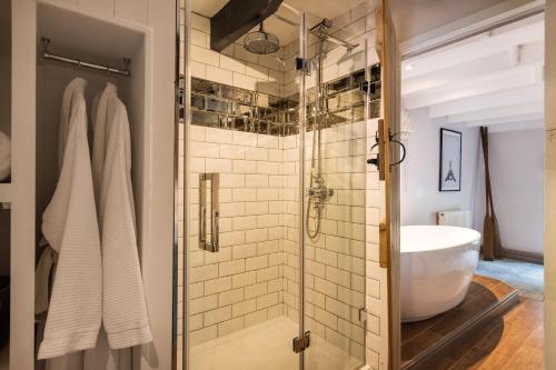 a bathroom with a glass shower with a white tub at The Hideaway at Tregoose Old Mill in Newquay