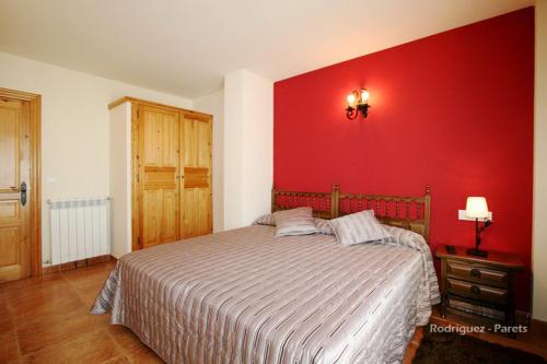 a bedroom with a bed with a red wall at El Pradón in Mar