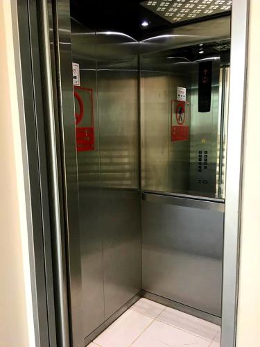 a metal elevator in a building with signs on it at Discoverequador in Tonsupa