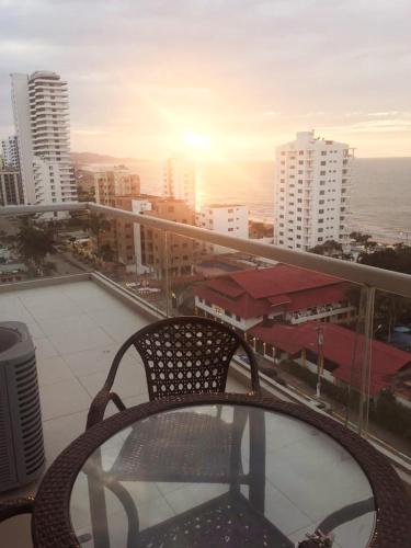 a chair on a balcony with a view of a city at Discoverequador in Tonsupa