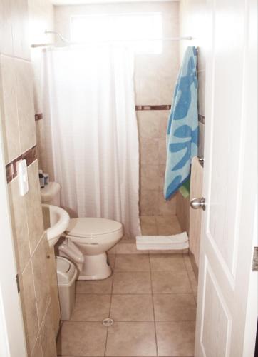 a small bathroom with a toilet and a shower at Discoverequador in Tonsupa