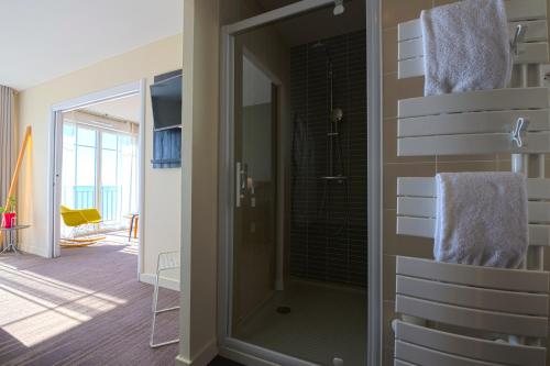 a bathroom with a shower with a glass door at Les Flots - Hôtel et Restaurant face à l'océan - Châtelaillon-Plage in Châtelaillon-Plage