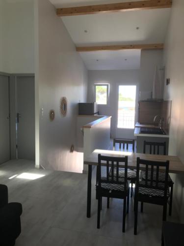 une cuisine avec une table et des chaises dans une pièce dans l'établissement LE CHAI DE LA CHARENTAISE, à Saint-Palais-sur-Mer