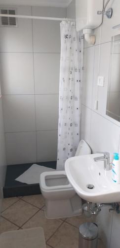 a white bathroom with a toilet and a sink at Love 2 Solkan in Nova Gorica