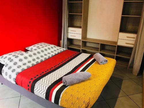 um quarto com uma cama com uma parede vermelha em La Madeleine em Cilaos