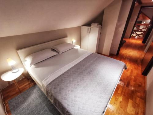 a bedroom with a large bed and a table with a lamp at Greencajt in Jakopovec