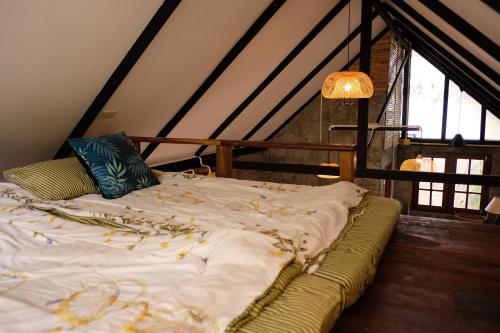 a unmade bed in a room with atained at Ashi Guesthouse Chiangdao in Chiang Dao
