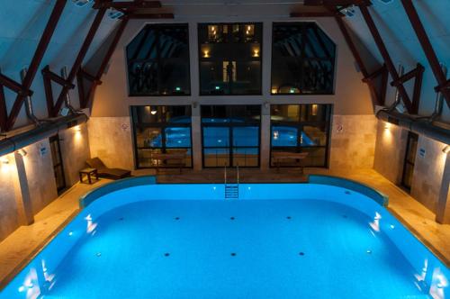 a large swimming pool in a house with a large window at Dwór Kresowy in Radymno