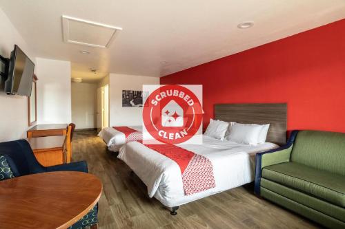 a hotel room with a bed with a red wall at OYO Hotel San Antonio near AT&T Center in San Antonio