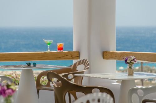
a dining room table with a balcony overlooking the ocean at Lianos Village in Agios Prokopios
