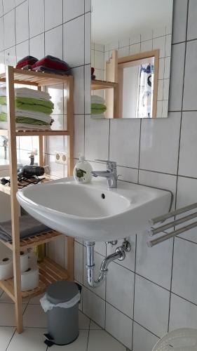 a bathroom with a white sink and a mirror at Ferienwohnung im Herzen Neuwied - Heddesdorf in Neuwied