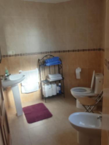 a bathroom with two toilets and a sink at Apartamento en Cuevas del Becerro in Cuevas del Becerro