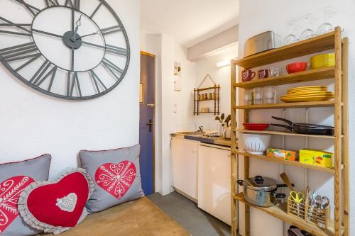 une cuisine avec une grande horloge murale dans l'établissement Travel Homes -The Cigogne, quiet & heart of Colmar, à Colmar