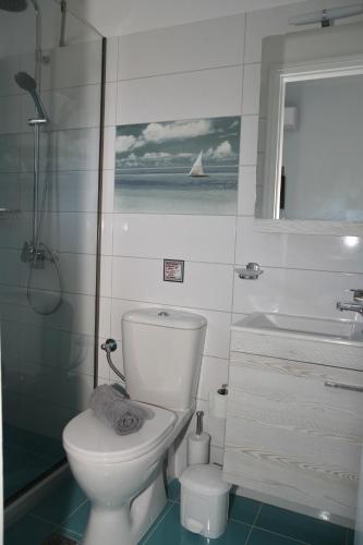 a bathroom with a toilet and a sink and a window at Terpsichore Boutique Appartments in Dassia
