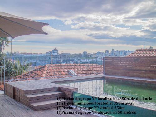 a swimming pool on a roof with a view of the city at ALIBI by YoursPorto in Porto