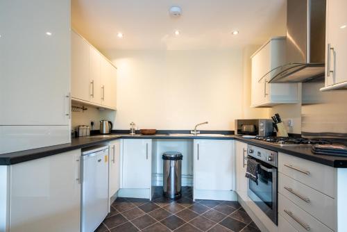 uma cozinha com armários brancos e um forno com placa de fogão em No6 Nursery Convent em Mansfield