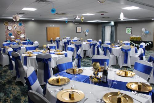 a banquet hall with blue and white tables and chairs at Holiday Inn Express Shawnee by IHG in Shawnee