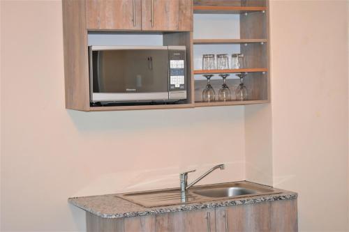 a kitchen with a sink and a microwave at Prime Hotel in Durban