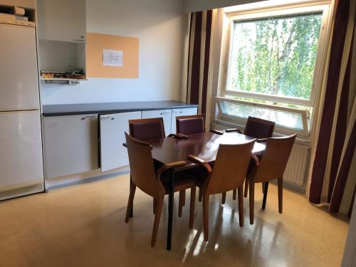 a dining room with a table and chairs and a kitchen at West Side Hotel in Turku