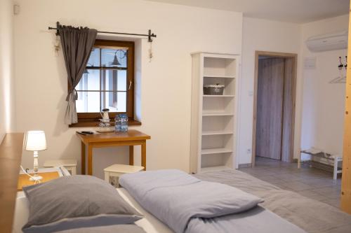 ein Schlafzimmer mit einem Bett, einem Schreibtisch und einem Fenster in der Unterkunft Penzion BLATNICE in Blatnice