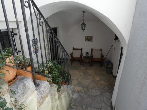 a hallway with a staircase with some plants and someitures at Apartments Getruda in Krk
